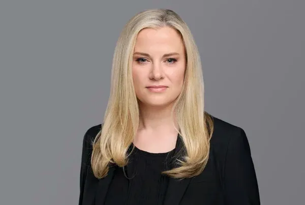 Kristin Koenig Professional Portrait Photo Professional headshot of Kristin Koenig with blonde hair wearing a black blazer against a gray background