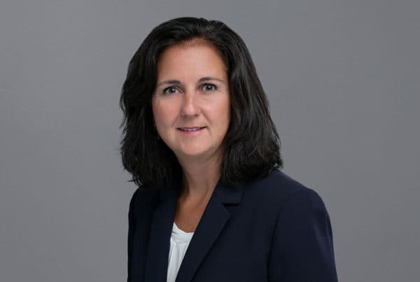 Professional Portrait of D. Richwine Professional headshot of D. Richwine wearing a navy blazer and white top against a gray background